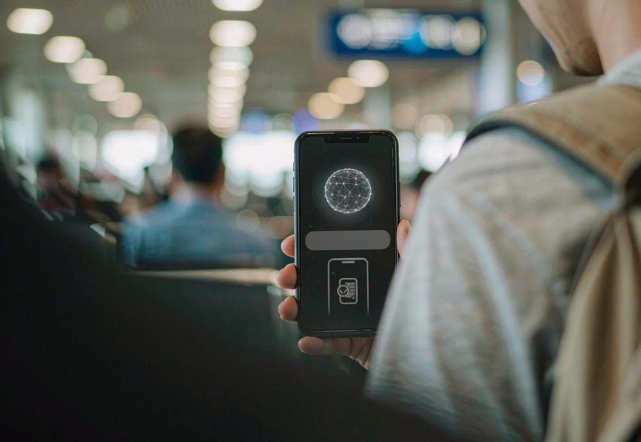 A traveller holding a smartphone with an eSIM and VPN app ready before landing in China