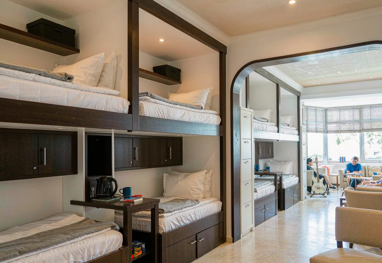 A bright hostel dorm with bunk beds and a social common area in China