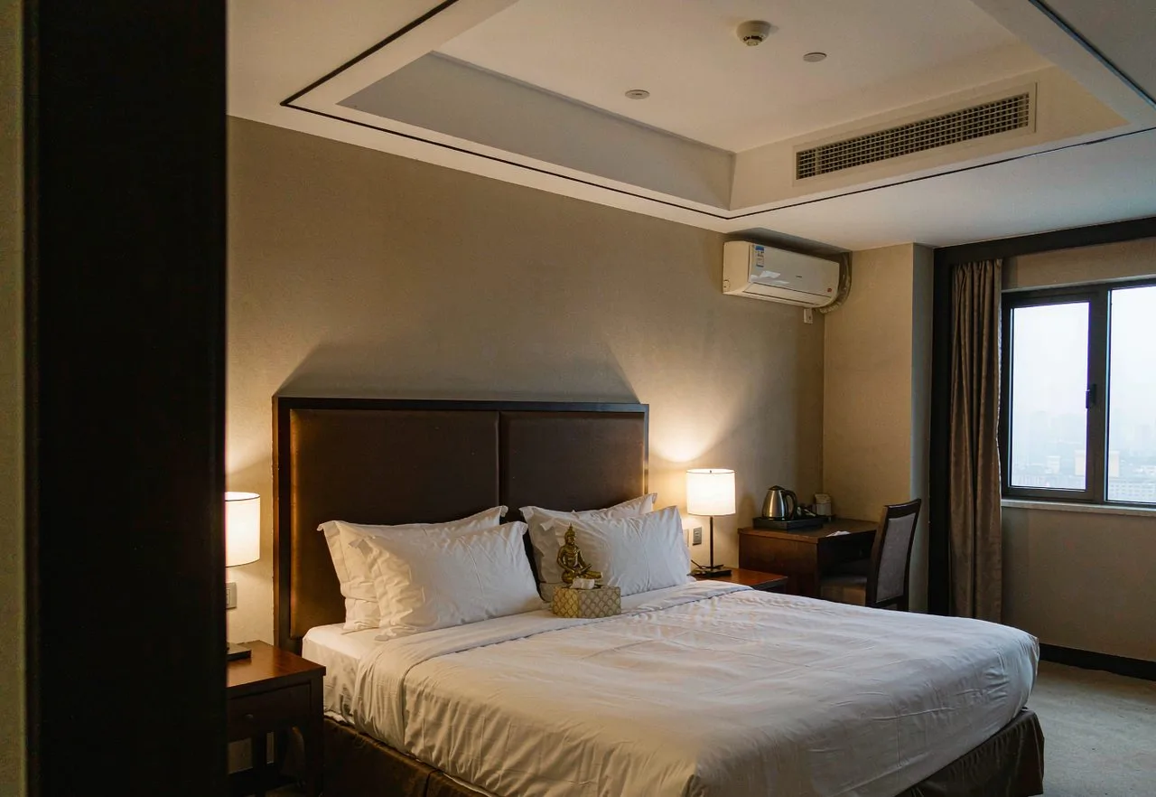 A clean modern budget hotel room in China with a real bed and city view
