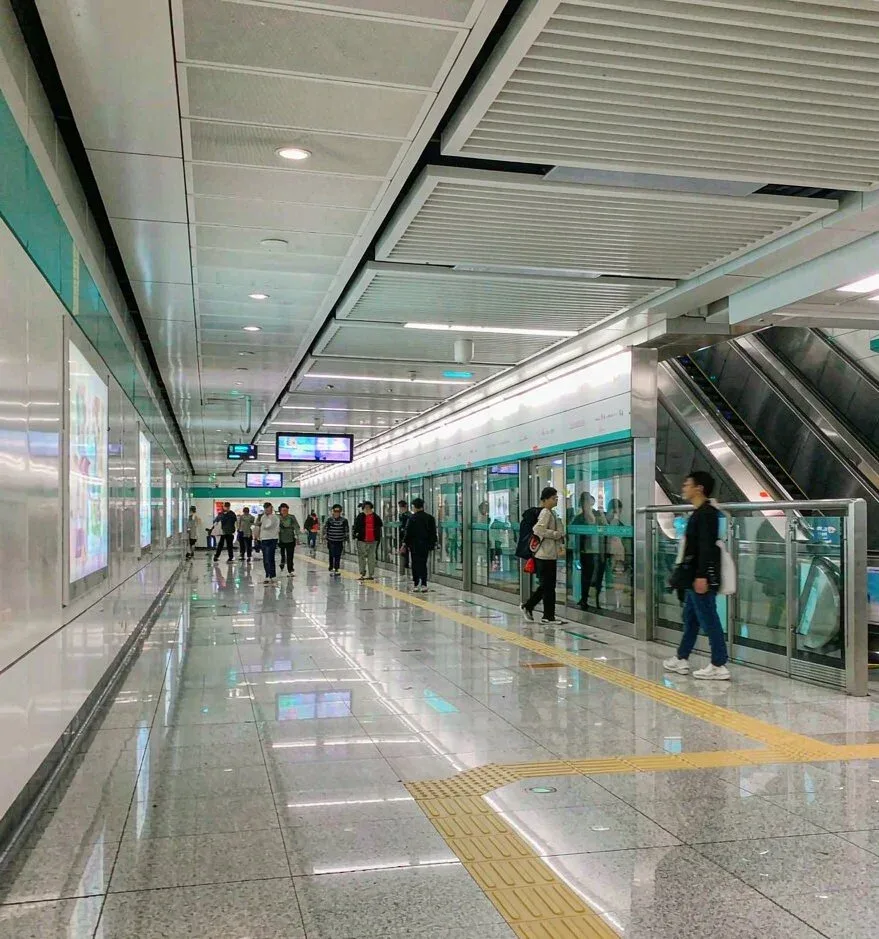 A clean Chinese metro station concourse with platform screen doors