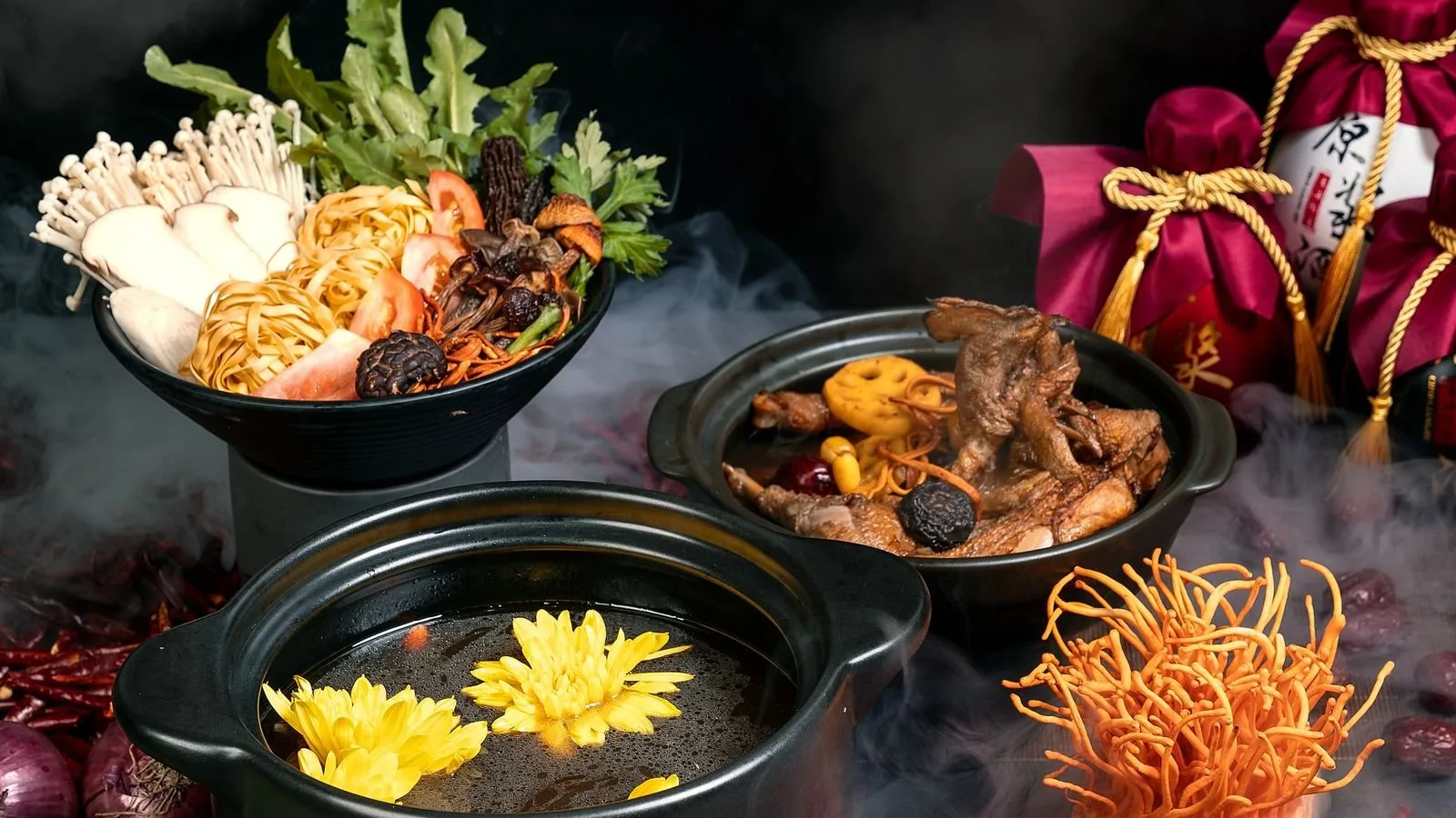 A bubbling Chinese hotpot with fresh ingredients on the table