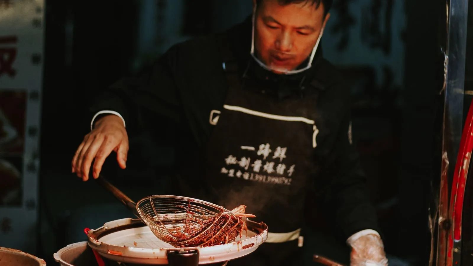 A vendor serving freshly cooked braised meats and sausages at a busy stall