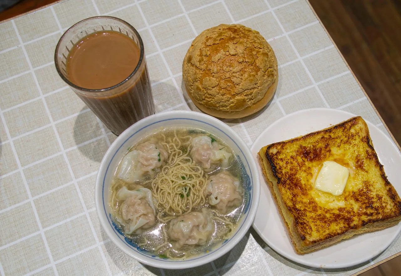A classic Hong Kong cha chaan teng meal with milk tea, pineapple bun and wonton noodles