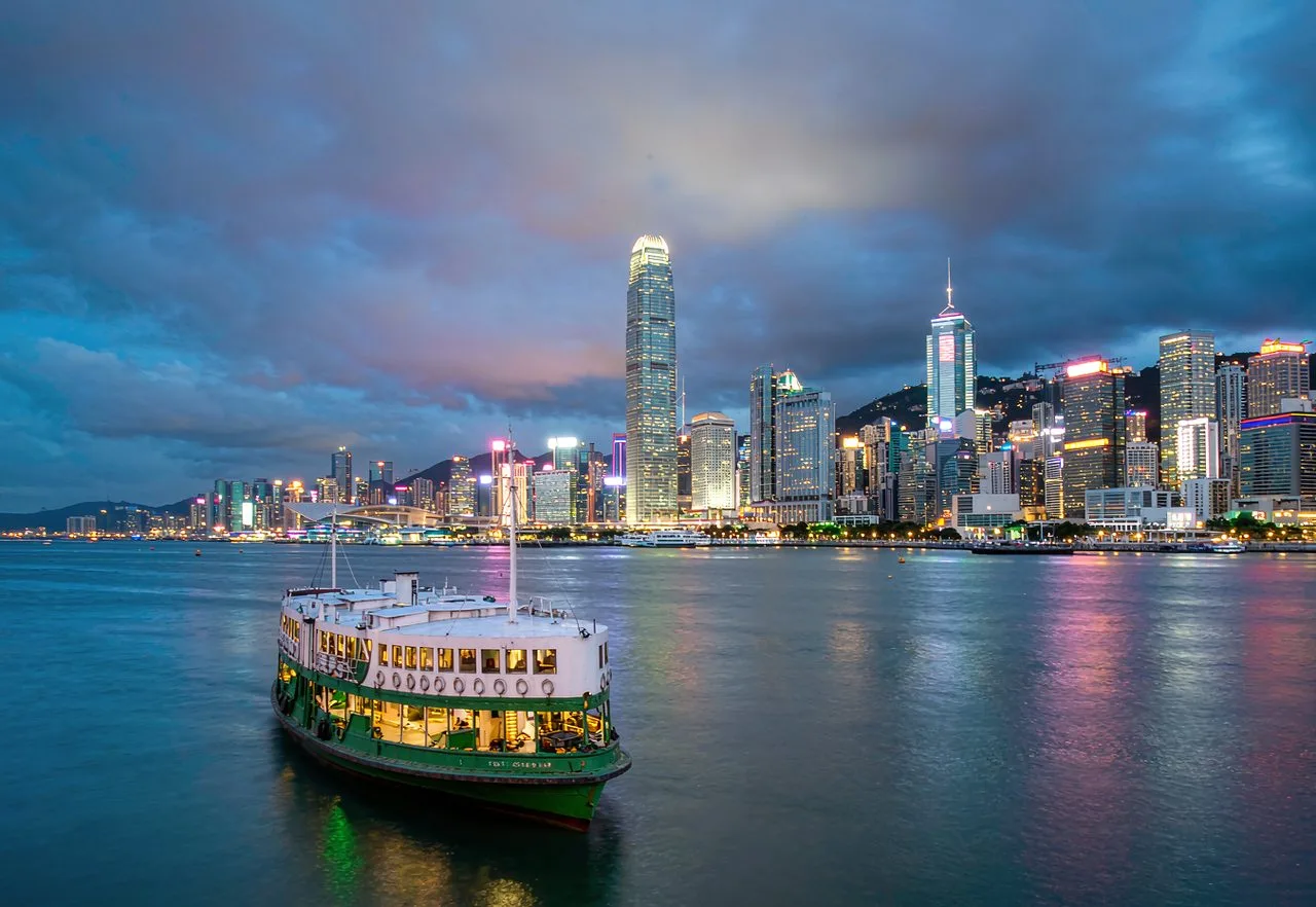 Hong Kong things to do: Victoria Harbour skyline at blue hour with a Star Ferry boat