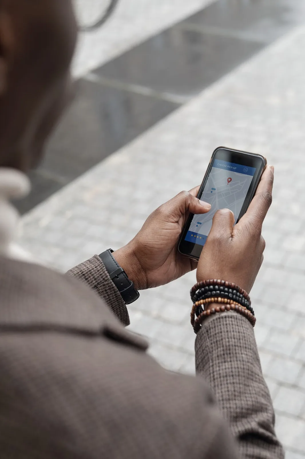 A traveler uses a phone map to navigate a city street