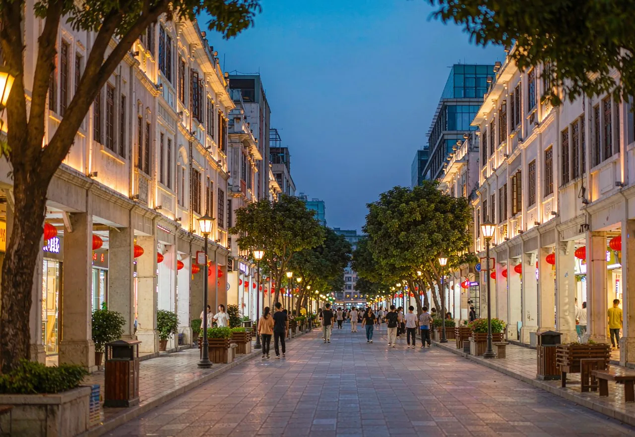 A calm, well-lit pedestrian street in a Chinese city at blue hour — safe travel in China, everyday urban life