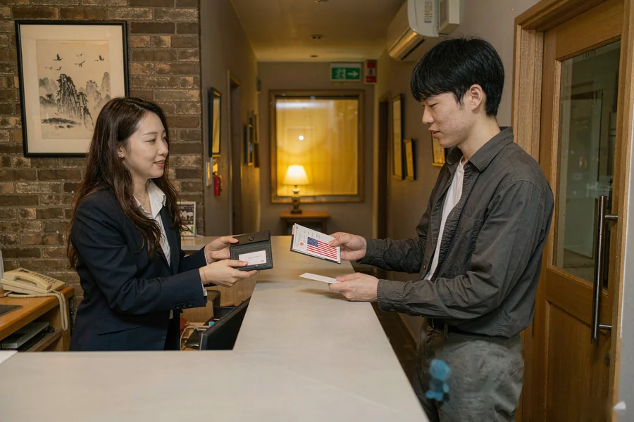 Checking in at a Chinese hotel front desk with passport and booking confirmation on a phone